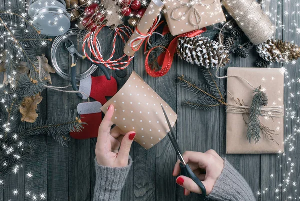 Vista dall'alto della donna mani taglio carta regalo per Natale prese — Foto Stock