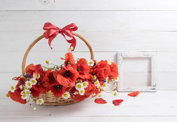 Gänseblümchen mit Mohnstrauß und Fotorahmen auf weißem Holz — Stockfoto