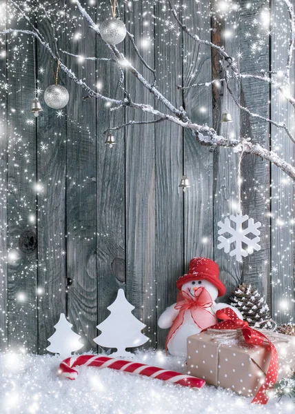 Weihnachtsdekoration mit Schneemann, dekorativen Zweigen, Geschenken und Zuckerstangen — Stockfoto