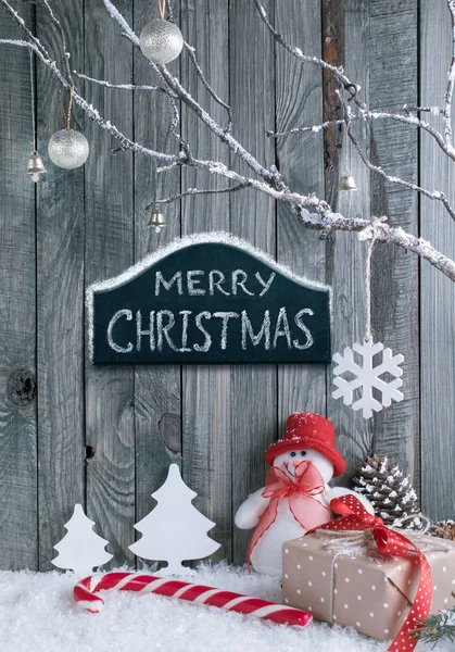 Kerst interieur met sneeuwpop, decoratieve takken, geschenken en snoep stokken — Stockfoto