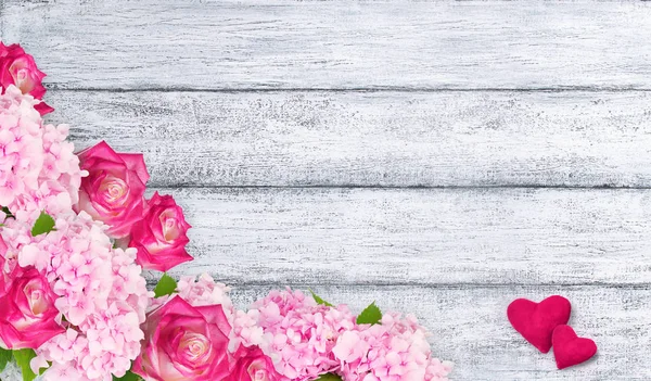 Rosas rosadas y hortensias con dos corazones sobre fondo de shabb —  Fotos de Stock