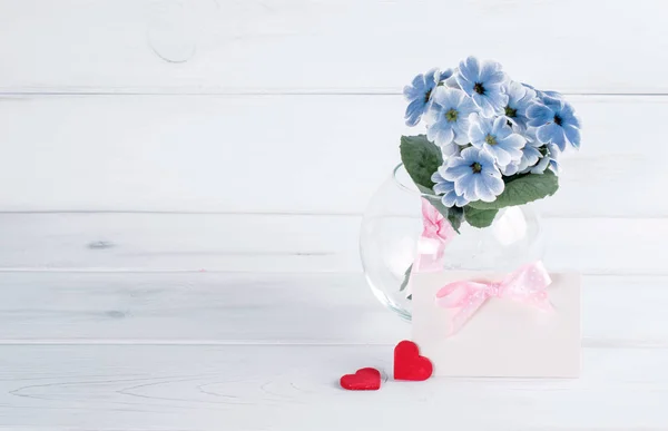 Primrose in vaso rotondo con biglietto di auguri e due cuori — Foto Stock