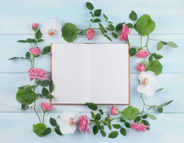 Marco floral consta de rosas y flores de orquídea y cuaderno — Foto de Stock