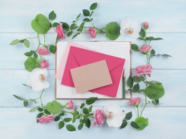 Blumenrahmen besteht aus Rosen mit Orchideenblüten und Umschlag. — Stockfoto