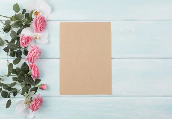 Fundo de madeira com rosas e orquídea e caderno vazio com — Fotografia de Stock