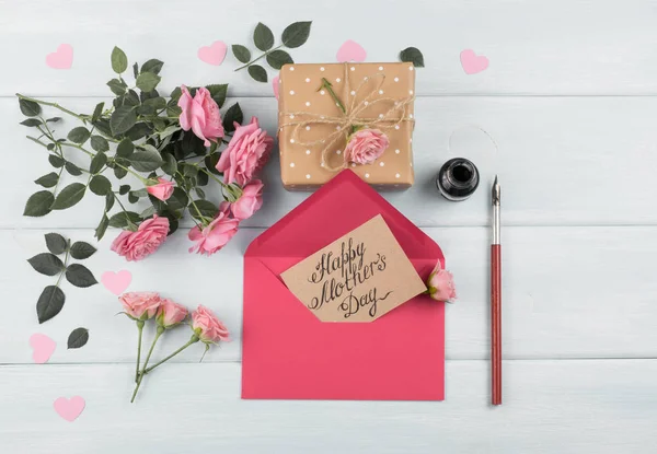 Rosas com envelope, cartão com texto de saudação e caixa de presente — Fotografia de Stock