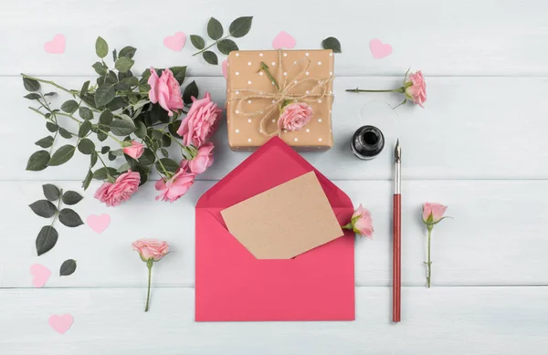 Rosas com envelope, papel em branco para saudação caixa de texto e presente — Fotografia de Stock