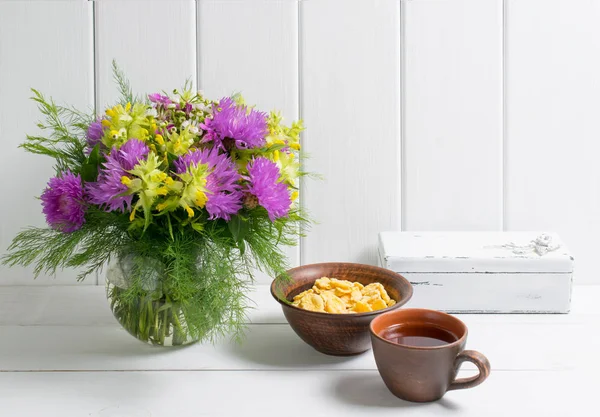 Buquê de flores em vaso com chá de xícara e flocos de milho — Fotografia de Stock