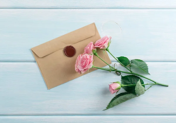 Fundo de madeira com rosas e envelope — Fotografia de Stock