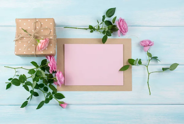 Fundo de madeira com rosas, caixa de presente e papel vazio — Fotografia de Stock