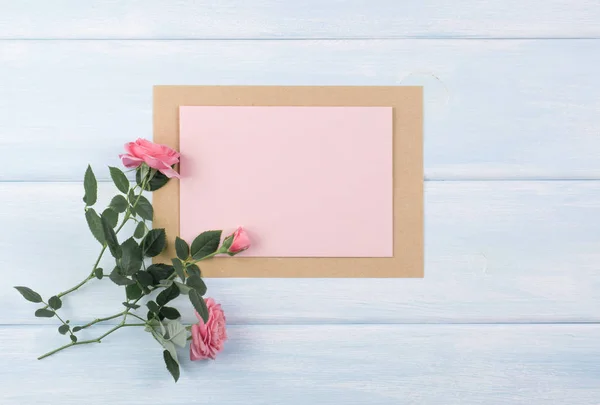 Holzhintergrund mit Rosen und leerem Papier mit Platz für Text — Stockfoto