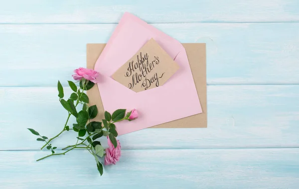 Rosas cor-de-rosa com cartão de saudação de papel para o dia das mães no envelope — Fotografia de Stock