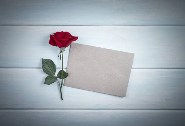 나무 판자에 종이 카드와 함께 빨간 장미 — 스톡 사진