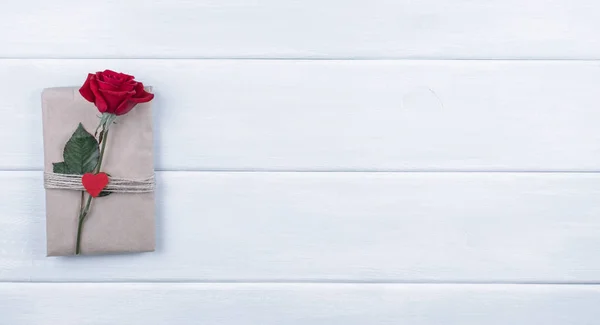 Červené růže wit dárek na pozadí omšelé dřevěné prkna s emp — Stock fotografie