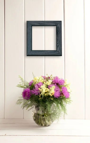 Bouquet de fleurs en verre vase rond sur fond bois — Photo