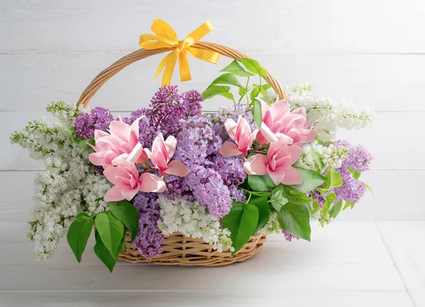 Bouquet de lilas et magnolia dans le panier sur fond de woo minable — Photo
