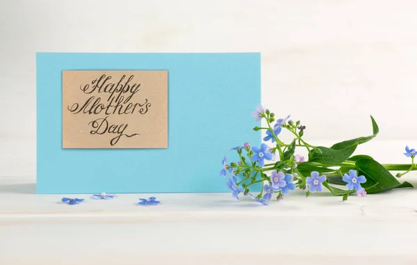 Forget-me-not flowers and paper greeting card for Mothers day — Stock Photo, Image