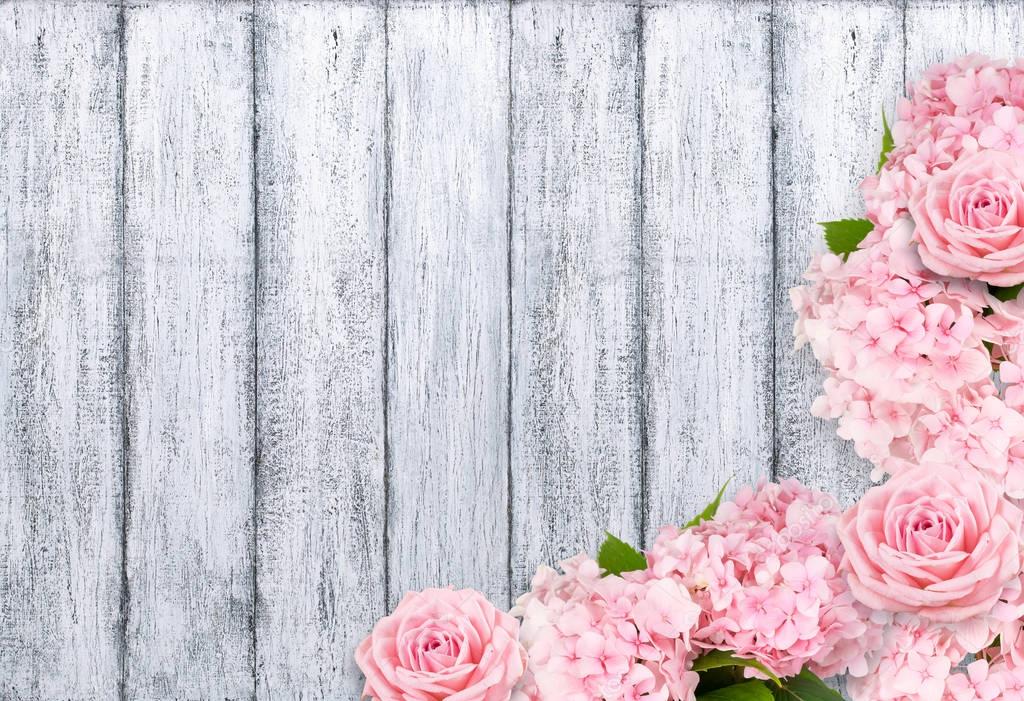 Roses and hortense on background of shabby wooden planks