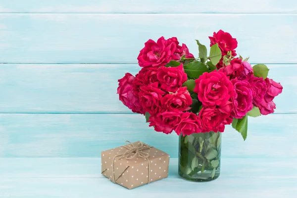 Roses bouquet and gifts on wooden background — Stock Photo, Image