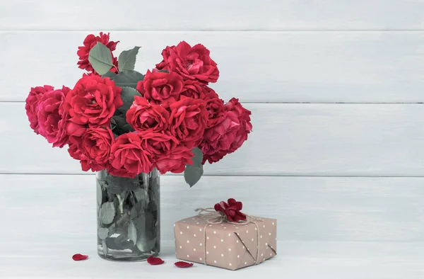 Bouquet di rose e regali su sfondo di legno — Foto Stock