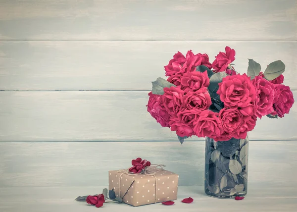 Roses bouquet and gifts on wooden background — Stock Photo, Image