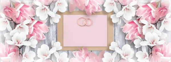 Magnolia, bruids ringen en papieren kaart voor bruiloft — Stockfoto