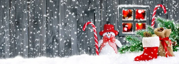 Bota Santa con regalos y muñeco de nieve sobre fondo de pared de madera —  Fotos de Stock