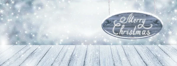 Christmas background with signboard, wooden table and snowfall — Stock Photo, Image