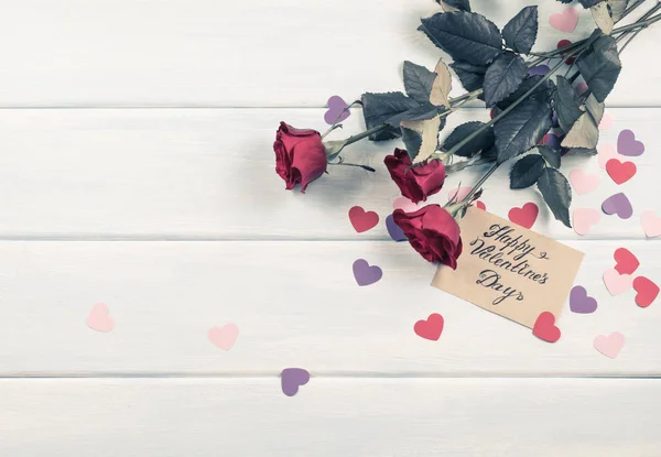 Червоні троянди з паперовими сердечками і вітальна листівка — стокове фото