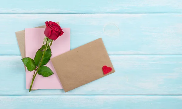 Valentine den téma. Červená růže, eco papír a obálky — Stock fotografie