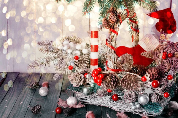 Sfondo di Natale con cesto di vimini, Babbo Natale stivale e cappello, candela e stella, abete, ghiande, pino, coni di abete rosso sul tavolo, Capodanno vacanze invernali arredamento materiale naturale — Foto Stock