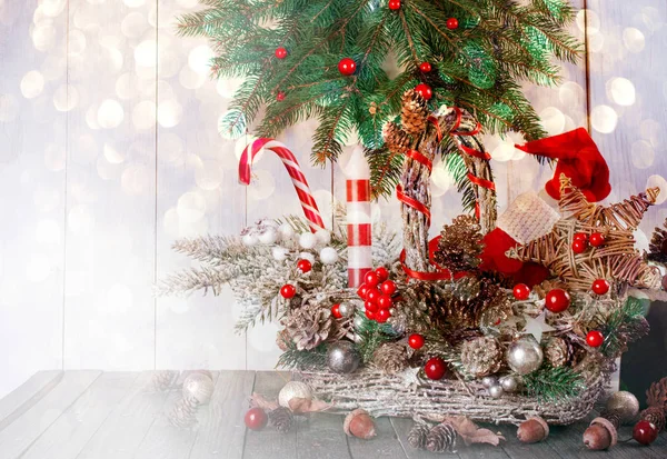 Fondo de Navidad con cesta, bota de Santa Claus, sombrero, vela, estrella, abeto, piruleta de bastón de caramelo en la mesa, decoración material natural de la casa de vacaciones de invierno de Año Nuevo —  Fotos de Stock