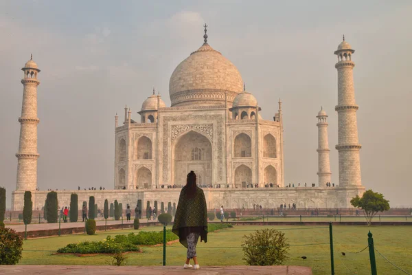 Genç bayan turist sabahın erken saatlerinde Taj Mahal 'e bakıyor.