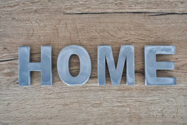 Gri ev tabelası ahşap masada.