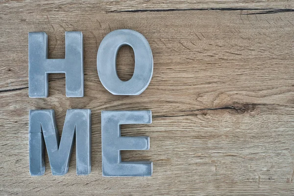 Gri ev tabelası ahşap masada.