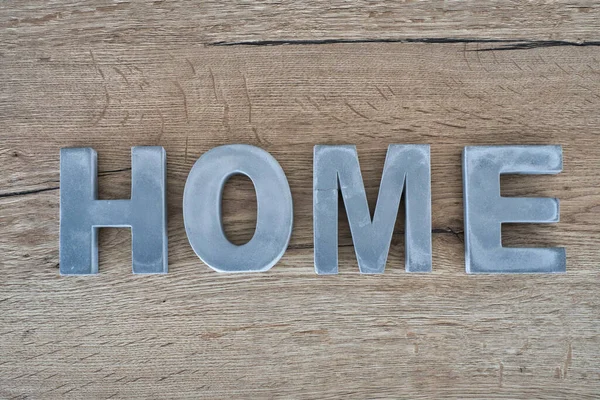 Gri ev tabelası ahşap masada.