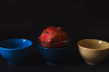 Siyah arka planda yemek için renkli kaseler.