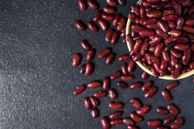 Koyu gri arkaplanda kırmızı sağlıklı fasulyeler