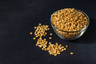 Siyah arka planda bir kasedeki sağlıklı bezelyeler.