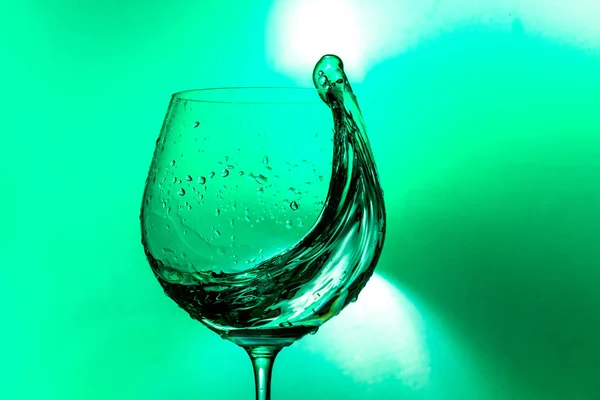 Spruzzata Acqua Bicchiere Vino Uno Sfondo Verde Chiaro — Foto Stock