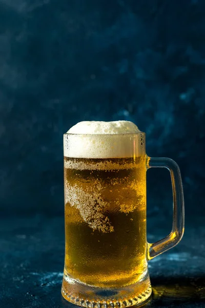 Gri taşlı arka planda bir bardak soğuk bira