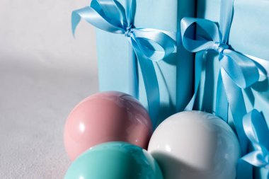 Renkli Noel baloları ve gri arka planda hediye kutusu