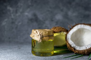 Hindistan cevizi arkaplanındaki gri taştan yapılmış hindistan cevizi yağı..