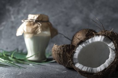 Hindistan cevizi arkaplanındaki gri taştan yapılmış hindistan cevizi yağı..