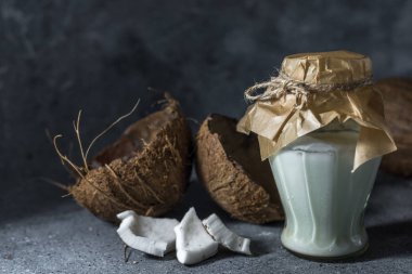 Hindistan cevizi arkaplanındaki gri taştan yapılmış hindistan cevizi yağı..