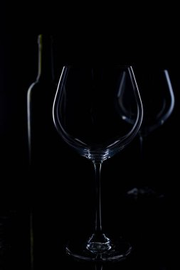 Siyah arka planda bir bardak kırmızı ve pembe şarap. Şarap listesi menüsü. Gözlüklerin ve şişelerin gücünü kapat.