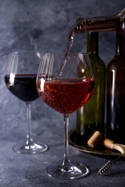 Kırmızı şarap. Şişe ve bir bardak kırmızı şarap. Eski tarz. Siyah arka planda kırmızı şarap. Metnin için boşluk ile tasarım yap.