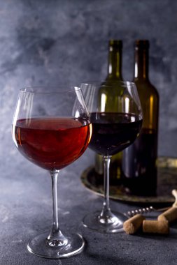 Kırmızı şarap. Şişe ve bir bardak kırmızı şarap. Eski tarz. Siyah arka planda kırmızı şarap. Metnin için boşluk ile tasarım yap.