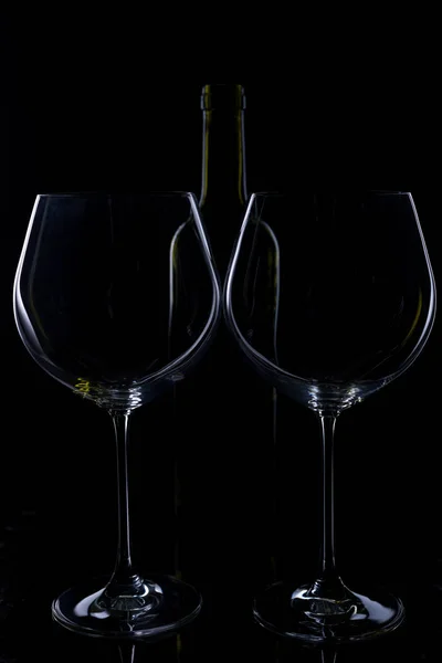 glass of red and pink wine on a black background. Wine list menu. Close up of the power of glasses and bottles in low key