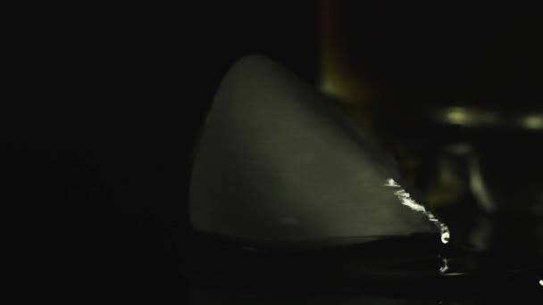 glaçons bleus tourner et se déplacer sur un fond sombre éclairé par une lampe lumineuse 